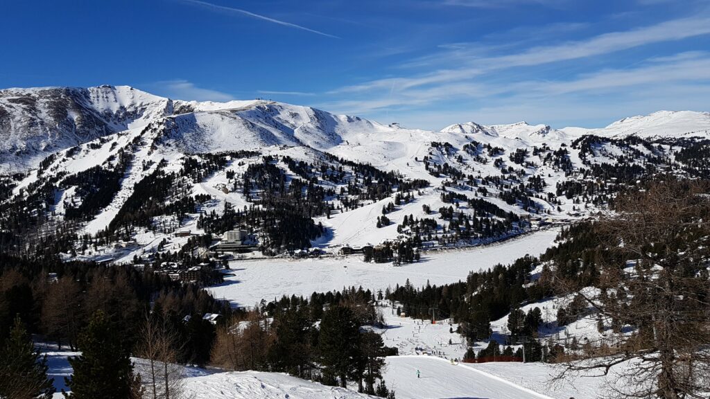 Turracher Hohe - panoramsli pogled na zaleđeno jezero i okolne skijaške staze