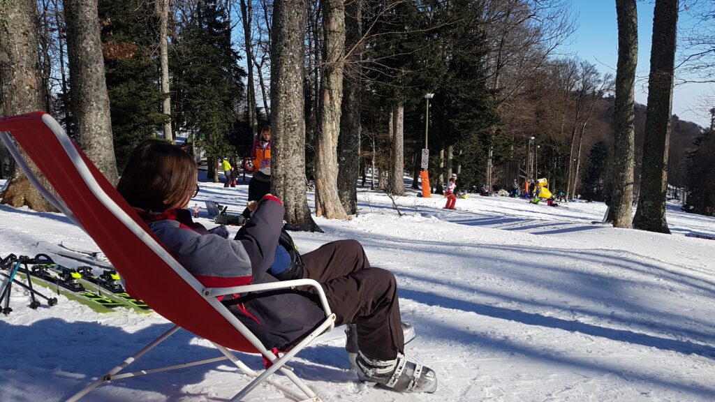Sljeme skijanje -skijašica odmara na ležaljci pored Sljemenske kućice