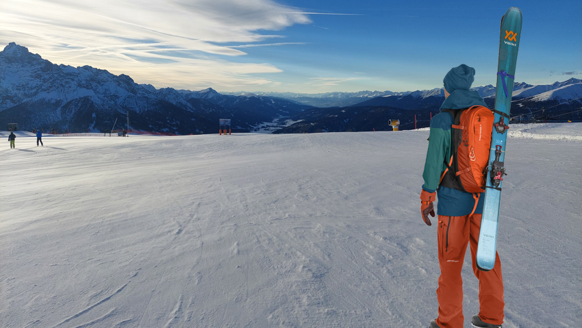 Skijaš sa skijaškim ruksakom i prikačenim skijama za ruksak.